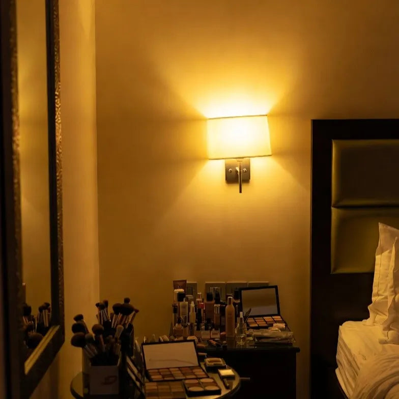 Makeup station with various products in a dimly lit room by Makeup Artist